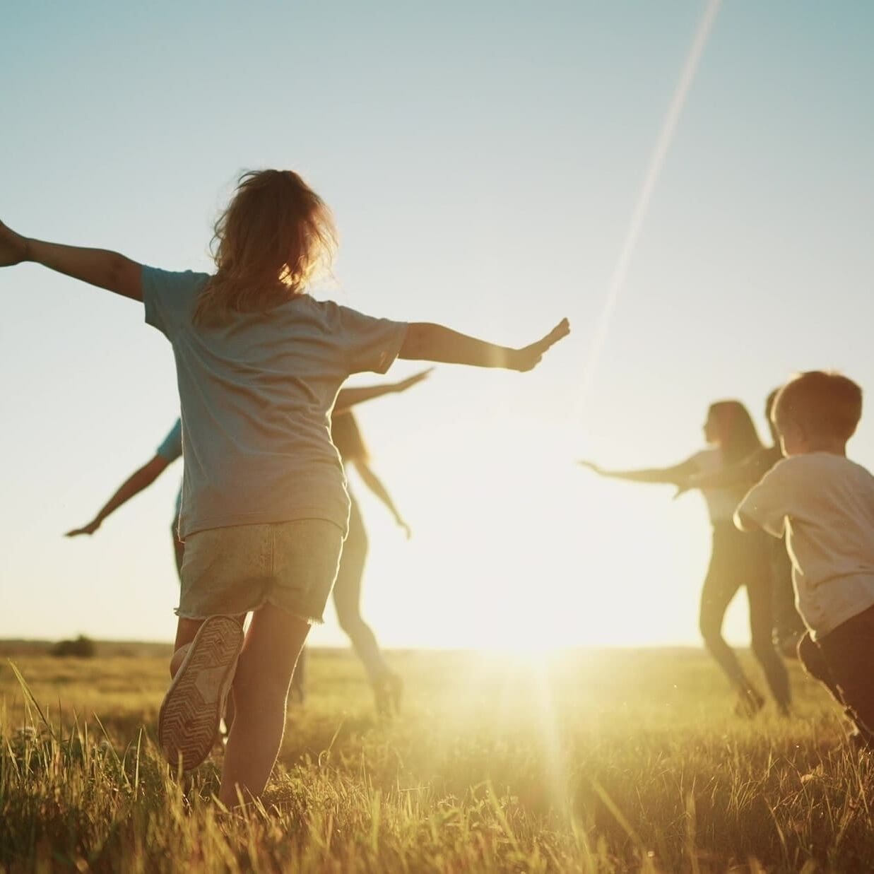 kids run in the park at sunset. friendly family children camp kid dream concept. group of children run on the grass at fun the rays of the sun silhouette. childhood sunset dream teamwork concept