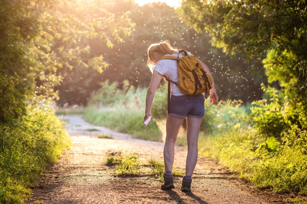 Woman applying insect repellent against mosquito and tick on her